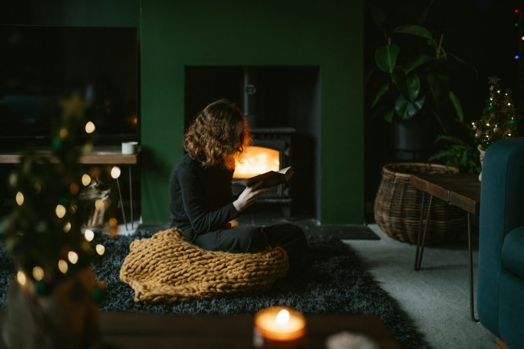 female reads in front of fire